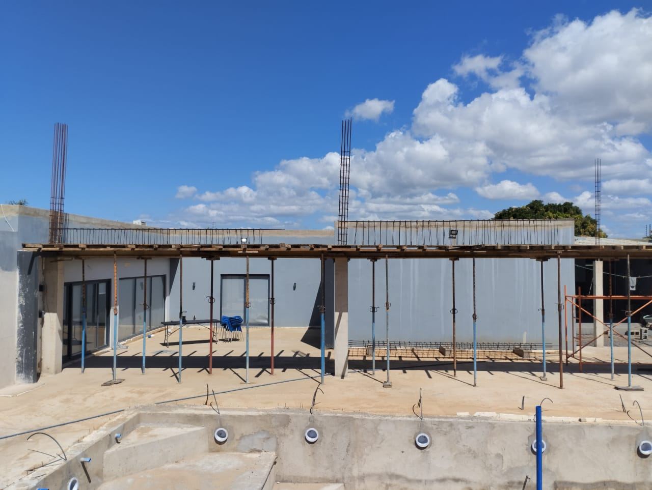 Edifício em construção com estrutura de betão e céu limpo